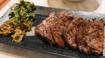 黒い皿に盛った焼いた牛たんと南蛮味噌
