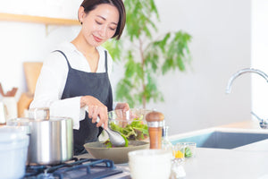 キッチンで鍋を使って調理する女性/blogs/column/sous-vide-gyutan-guide