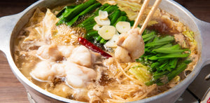煮立ったもつ鍋から箸でもつを持ち上げたところ/blogs/column/motsunabe-recipe