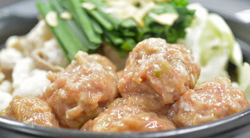 黒い鍋に入れたつくねと、にら、キャベツ、豆腐