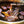 Load image into Gallery viewer, 伊達のくら秘伝のタレで漬け込まれた牛カルビの焼き肉、炭火で焼かれる様子を捉えた画像。赤身と脂身のバランスが良く、ジューシーさが際立つ。
