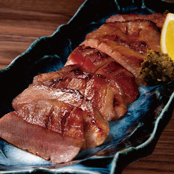 焼き目が美しい牛たんブロックのスライス、ジューシーで香ばしい風味が特徴、レモンとわさび添え