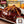 Load image into Gallery viewer, 牛たんハンバーグのアップ写真、ジューシーな肉質と特製ソースがかかっている。120gのパックで、付け合わせに野菜が添えられている。
