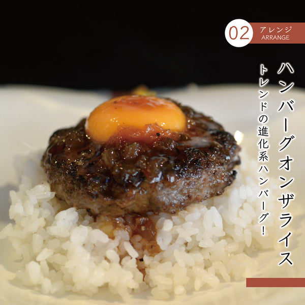 牛たんハンバーグセットの料理写真。ジューシーな牛たんハンバーグに生卵がトッピングされ、白ご飯の上に盛り付けられています。和風のソースがかかっており、食欲をそそるアレンジスタイル。