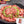 Load image into Gallery viewer, 焼肉用の牛たん中切り落とし、200gパック、薄切りで新鮮な肉が盛り付けられた皿の上にネギが散りばめられた様子。
