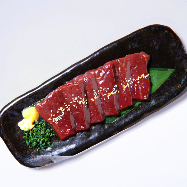 黒毛和牛の新鮮なレバーのスライスを盛り付けた皿、上にはごま、わさび、ネギが添えられた美しいプレゼンテーション